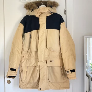 Vinterjacka  - Säljer denna fina, nya vinterjacka! Beige/gul och svart. Strl L. Oanvänd. Köpt för 1499 kr! Pris kan diskuteras