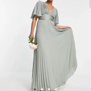 Balklänning - Plisserad balklänning med utsvängda armar och omlottsmidja och dragkedja, strl 32 i en kall och ljus grön färg. Aldrig använd då jag valde en annan balklänning till slut, nypris: 1069kr från ASOS