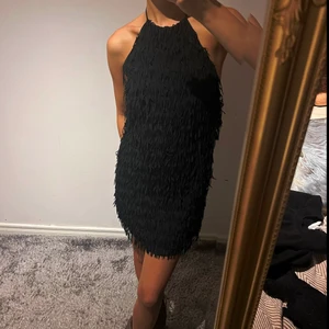 Klänning med fransar  - Svart festklänning med fransar och så fin öppen rygg!