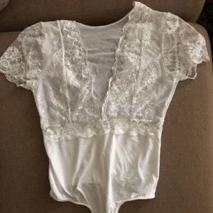 Vit spets body - Vit spets body i mesh snygg öppen rygg. Helt ny och oanvänd. Strlk XS/S.