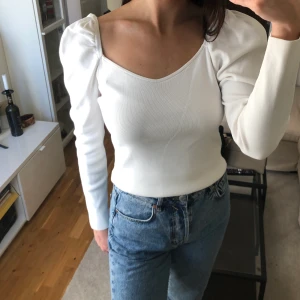 Vit långärmad tröja NA-KD - Vit jättefin långärmad tröja från NA-KD. Skönt material som faller snyggt på kroppen. Lite längre så går både att ha den längre eller instoppad/invikt. Puffiga långa armar. Storlek M. Fin bred ringning. Använt skick