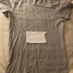 Balmain Grey T-shirt - Cond 9/10, använt fåtal gånger, inga flaws eller dylikt. Storlek M, sitter lite för tight på mig som är 192cm lång. Kvitto finns via farfetch.  Nypris 2000kr  Fast pris.  Köparen står för frakten.