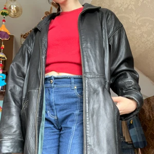 Lång skinnjacka - Mysig skinnjacka som håller värmen bra! Använt som vinterjacka utan problem! Delbar dragkedja som går hela vägen upp i kragen. Till knäna på mig som är 172!