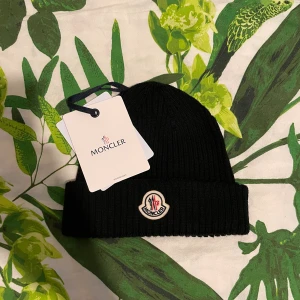 Moncler Mössa - Säljer min ÄKTA moncler mössa som är ny. Perfekt nu när det börjar bli kallare ute! NFC scan och QR kod fungerar som det ska!