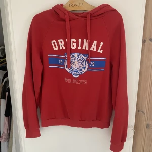 Röd luvtröja  - Röd hoodie från Gina tricot. Den är i använt skick, texten har spruckit lite som man ser på bilden