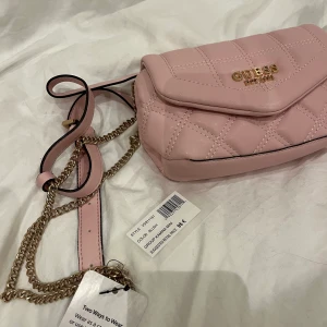 Ny GUESS mag/axel väska - Den är köpt på Zalando för ett tag sen men den kom aldrig till användning. Den är helt ny med prislappen på. Man kan ha den som en mag väska eller som en vanlig. Köparen står för frakten. 
