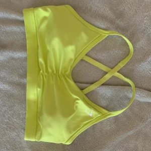Gymshark sportbh - Helt ovanvänd skrikgul sport-bh från gymshark, säljs pga passar ej mig. Väldigt små i strl så passar mer en S/XS. Köparen står för frakten!
