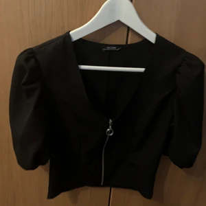Svart blus  - Svart blus med dragkedja på framsidan 
