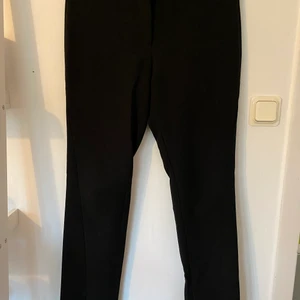 NA-KD kostymbyxor strl 36 - Svarta byxor med slits nertill. Använda men i bra skick, nån noppa kanske.