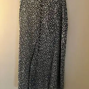 Jättefin kjol från &Other Stories med knappar och en slit fram. Mörkblå med vita blommor. Ser ut som ny. I storlek XS.