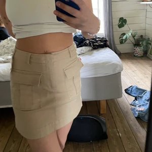 Beige jeanskjol - Beige jeanskjol med två fickor på framsidan. 