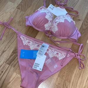 Bikiniset  - Rosa/ spets bikiniset från H&M. Nyskick. Underdel- Tie Tanga low rise, storleken 40. Bikiniöverdel push up. Storlek 80A.