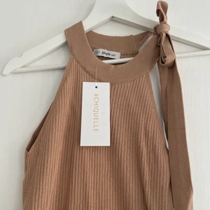 Ribbat linne  - Superfint beiget halterneck linne! Tyget är ribbat och vid halsen är det band som man självklart kan reglera som man önskar! Jag själv tycker linnet är väldigt smickrande, men har tyvärr inte hunnit använda det då jag äger x antal för många toppar, så väljer därav att sälja denna skönhet!😻💕🙏🏻  Strl one size  Pris kan diskuteras!