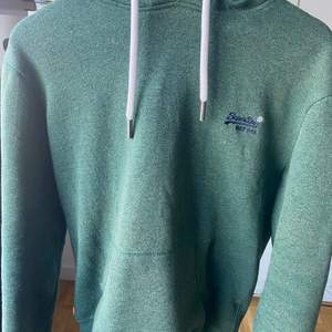 En grön superdry hoodie med ordinarie pris på 700kr, fortfarande riktigt bra skick. Ingen märken och tröjan är inte förstörd på nått sätt. Tröjan är för herr i storlek medium 