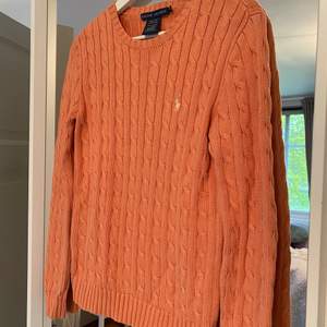 En kabelstickad tröja från Ralph lauren i en magisk orange färg. Knappt använd så i nyskick. 