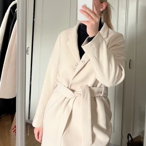 Beige kappa - Säljer denna beige kappan från hm, knappt använd så i jättebra skick. Bälte medföljer. Köparen står för eventuell fraktkostnad #kappa 