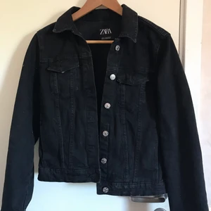 Svart jeansjacka från Zara strl M - Fin svart jeansjacka från Zara i väldigt bra skick då den endast är använd fåtal gånger. Strl M men skulle säga att den sitter mer som en S. Köparen står för frakt alt mötas upp i Lund💕