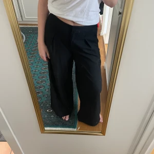Vida svarta kostymbyxor från Carin Wester strlk 42 - Vida kostymbyxor från Carin Wester, avslappnad passform med pressveck. Riktigt bekväma, högmidjade. Knappt använda! Passar en 40 också.