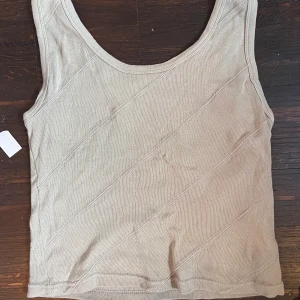 Tanktopp - Skitcool tanktopp med insytt mönster! Färgen är grå med grön underton! 