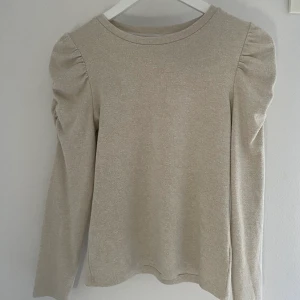 Tröja - Beige tröja med söta detaljer på axlarna från Lindex i stl xxs/xs. Använt sparsamt. (Nypris 199kr)  Köparen står för frakt!