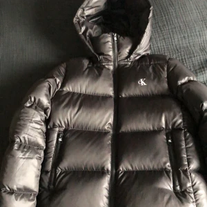 Vinterjacka Calvin Klein - Säljer nu denna vinterjackan från Calvin Klein Jeans i storlek S. Den har en avplockbar luva. Inuti jackan finns det en liten lagning som knappt är synlig. Jackan är använd väldigt lite och är 9/10 skick. Pris 1200,- nypris ca 2400,- 