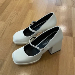 Mary Janes klackskor - Vita plattform mary janes från Monki i nytt skick! Helt oanvända eftersom de var lite för stora för mina fötter. Tar swish. Köparen står för frakt. Kan mötas upp i Stockholm.