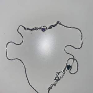 Silverfärgat halsband med lila hjärta i mitten