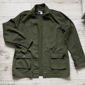 Khakigrön militärjacka <3 - Oanvänd khakigrön militärjacka 🖤Jackan har två fickor med knappar och två fickor med dragkedja. Jackan har knappar vid ärmslutet. Storlek 34 men passar 36 och kanske även 38! 