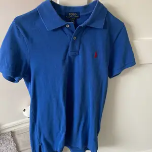 Pikétröja fr Ralph Lauren i St 12-14 år varsamt använd hel & fin Ribbad krage Knäppning fram  Broderad logga på bröstet  pris 450:-  Nypris 699:-