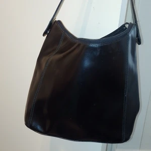 Frenzi väska  - Väska i äkta läder, finns en stor ficka inuti med dragkedja,mobilhållare och även en liten mindre ficka. Små slitage skador men inget som man lägger märke till därav priset. Om ni vill ha den spårbart så säg till.