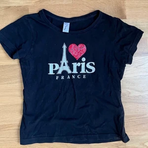 Baby tee - Lånad bild! ”I ❤️ Paris” -baby tee med strass. Köpt på plick och aldrig använd. Tror den är från barnavdelningen men passar mig som har xs/s. Fint skick men lite slitage på hjärtat då några stenar ramlat av. Skriv privat om du undrar något 