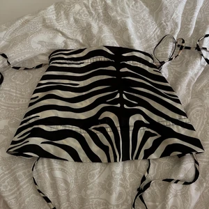 Topp - Topp med zebra mönster från gina tricot! Knyts bak på ryggen. Använd fåtal ggr, i bra skick! Skriv privat för fler bilder! (köparen står för frakt)