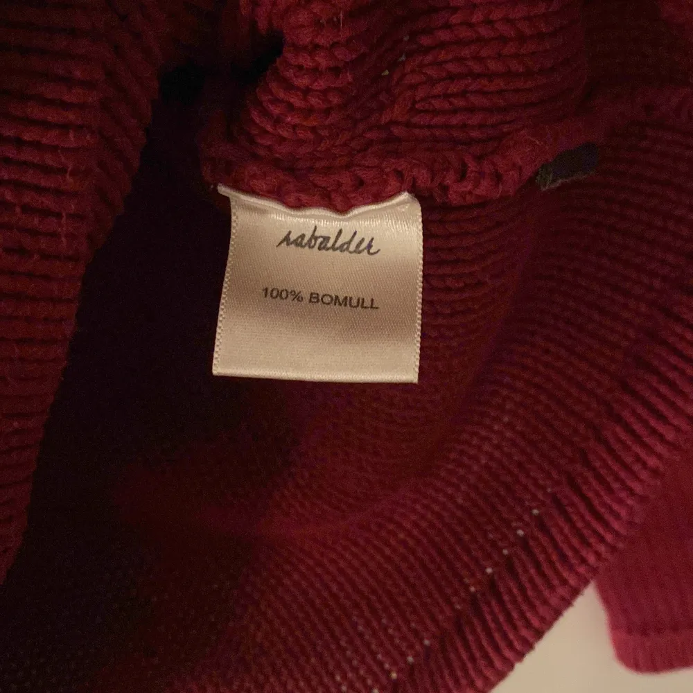 Lila/röd (typ plommon) stickad tröja från Rabalder, storlek M. . Stickat.