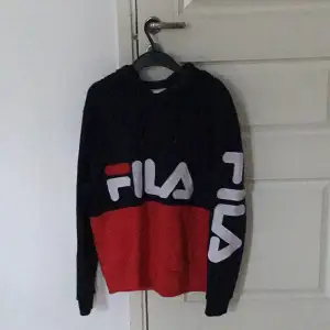 En röd/blå/vit Fila hoodie som knappt har används. Den är som ny. 