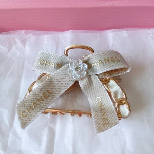 Hårklämma gjordes av Chanel band - Väldigt fin hårklämma med rosett i vit färg. Äkta Chanel band. Kolla gärna mina andra annonser.  Vanlig frakt kostar 13:-