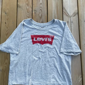Grå Levis cropped t-shirt  - Säljer denna snygga Levis t-shirten då den inte längre kommer till användning. 