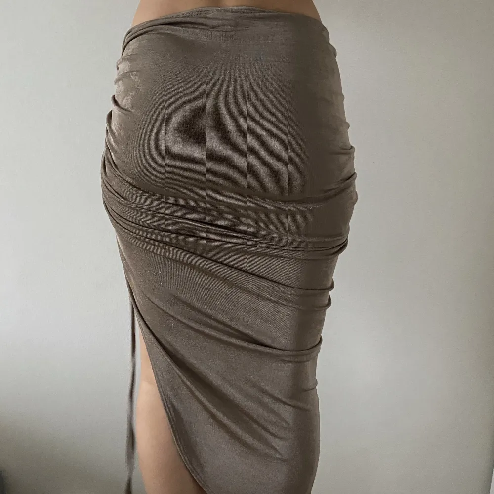 Kjol med slits i glittrigt beige tyg. Ej genomskinlig. Stretchiga Passar xs/s/m. Bra skick. Nypris: 450 kr Säljer för: 200 kr. Kjolar.