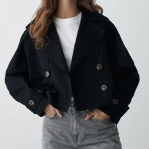 Kort trenchcoat Gina Tricot - Helt ny croppad trenchcoat med lappen kvar från Gina Tricot. Slutsåld på hemsidan. Säljer för tiden för att skicka tillbaka har gått ut. Storlek L, sitter snyggt på mig som vanligtvis har S/M.