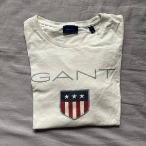 Gant T-shirt  - Säljer nu min vita gant t-shirt. Den är i använt skick, men utan några defekter. Den är i storlek S men är stor i storleken. Nypris 499kr, säljer för 100kr.  Tveka inte att höra av dig vid funderingar!