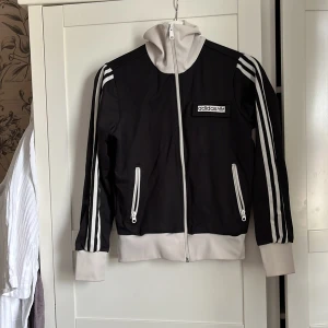 Adidas-jacka - Köpt secondhand men sitter tyvärr inte bra på mig. Fint skick men har tre st sådana här små fläckar som förvisso inte syns alls mycket på helheten men som ändå finns där. Utöver det inte nämnvärt sliten. Från halsen och ner ca 56 cm lång. 