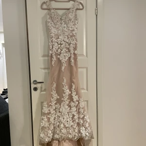 Klänning - Exklusiv beige balklänning med spets. Avtagbart släp. 
