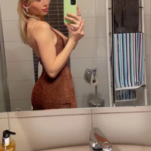 Glittrig klänning  - Glittrig klänning från h&m med öppen rygg Storlek XS men passar även mig med S  Använt en gång, mycket bra skick! 