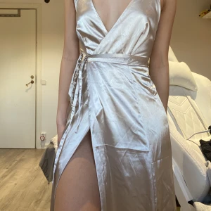 Bubbleroom klänning - Endast använd en gång, kan knytas på olika sätt (där fram elr bak). Passar mig (160cm) perfekt med klackar. Öppen rygg med satin liknande material och ett split på sidan av klänningen, OBS Splittet syns inte om man står rakt! Pris är exklusive frakt! 🫶