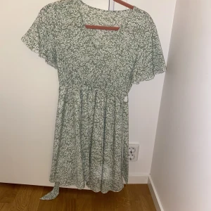 Sommarklänning  - Jätte söt ljusgrön sommarklänning med band att knyta runt midjan. Oanvänd! 