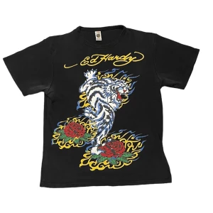 Ed Hardy Tröja - En riktigt fet Ed Hardy tröja med coolt tryck och rhinestones. Den sitter som M. Priset är inte skuret i sten, öppen för prutning. Köparen står för frakt. En del rhinestones har ramlat av men annars är den finfin:)
