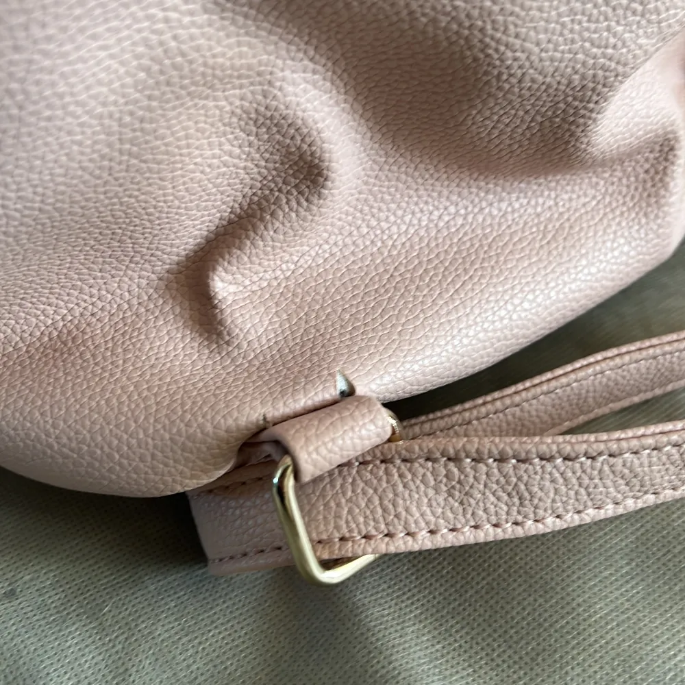 Rosa Guess ryggsäck, lite sliten baktill men går att använda om man ej har tunga saker i den. 30cm hög, 28cm bred och 12 cm djup.. Väskor.