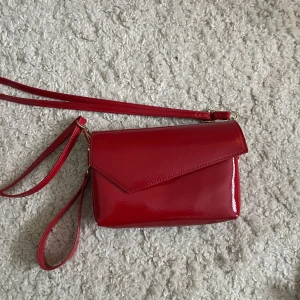 Röd väska i lack - En röd väska i lack med justerbart band