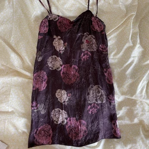 Klänning - Brun mini klänning med blommor. Satin aktigt material. 