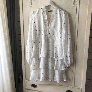 Sommarklänning studentklänning  - Så fin sommarklänning som även passar perfekt till studenten. Vit med svarta prickar. Volang och schiffong. Transparent. Strl 40 från Gina Tricot