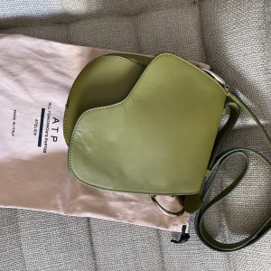 ATP Atelier väska - En grön väska från ATP Atpeleir. Säljs billigt pga av att lädret mjuknat efter många stunder i regn. Annars fint skick. Ordinarie pris: 4800